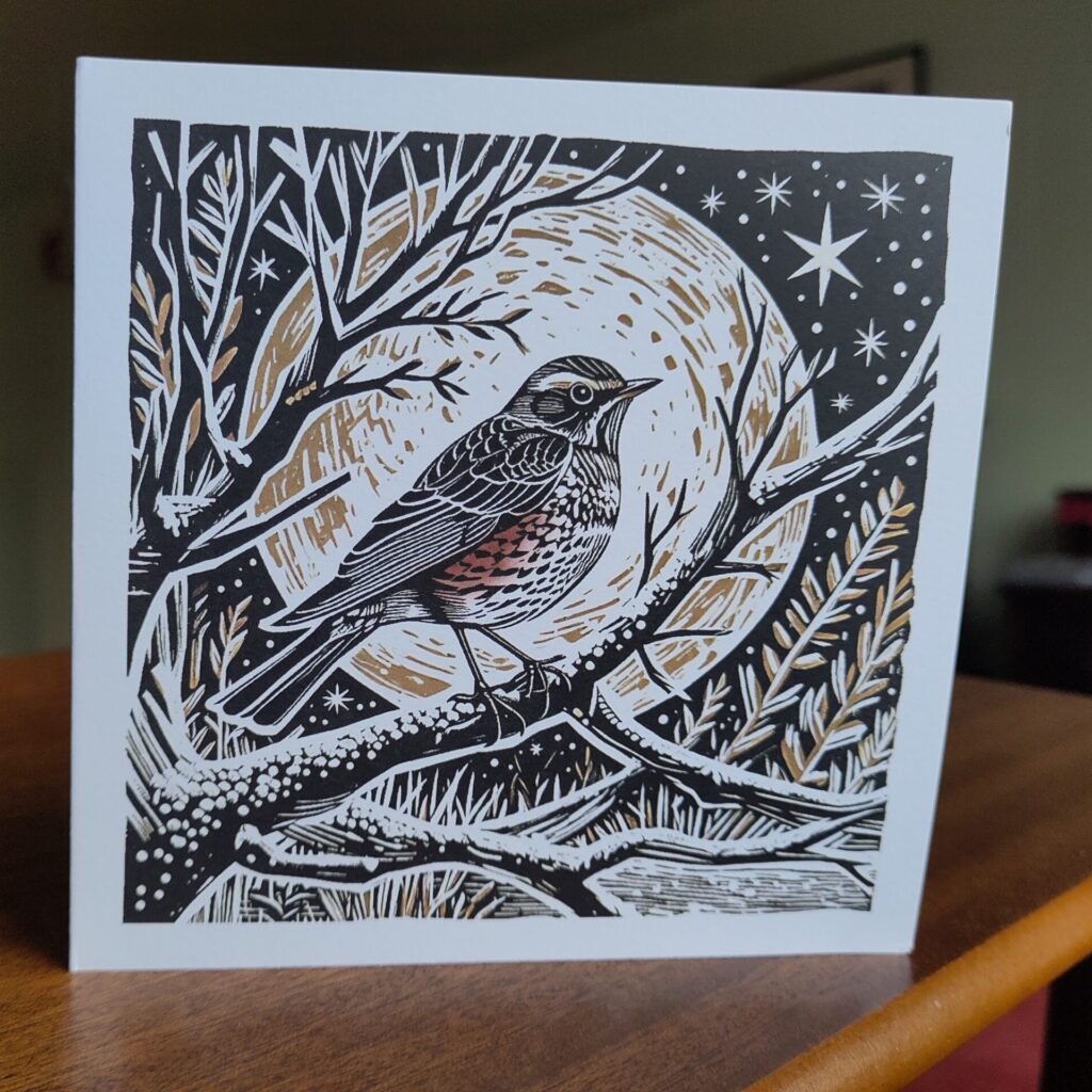 Christmas card with print of a redwing against a giant moon