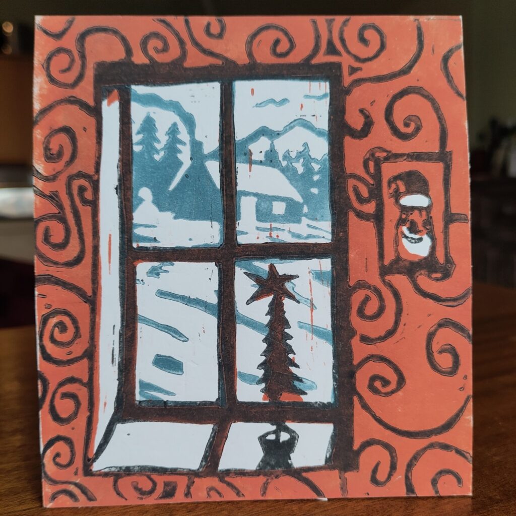 Handmade Christmas card showing a snowy scene seen through a windo